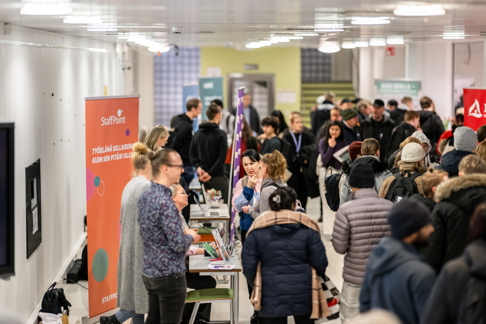 Ihmiset kulkevat näytteilleasettajien pisteillä rekrytointitapahtumassa Fellmanniassa.