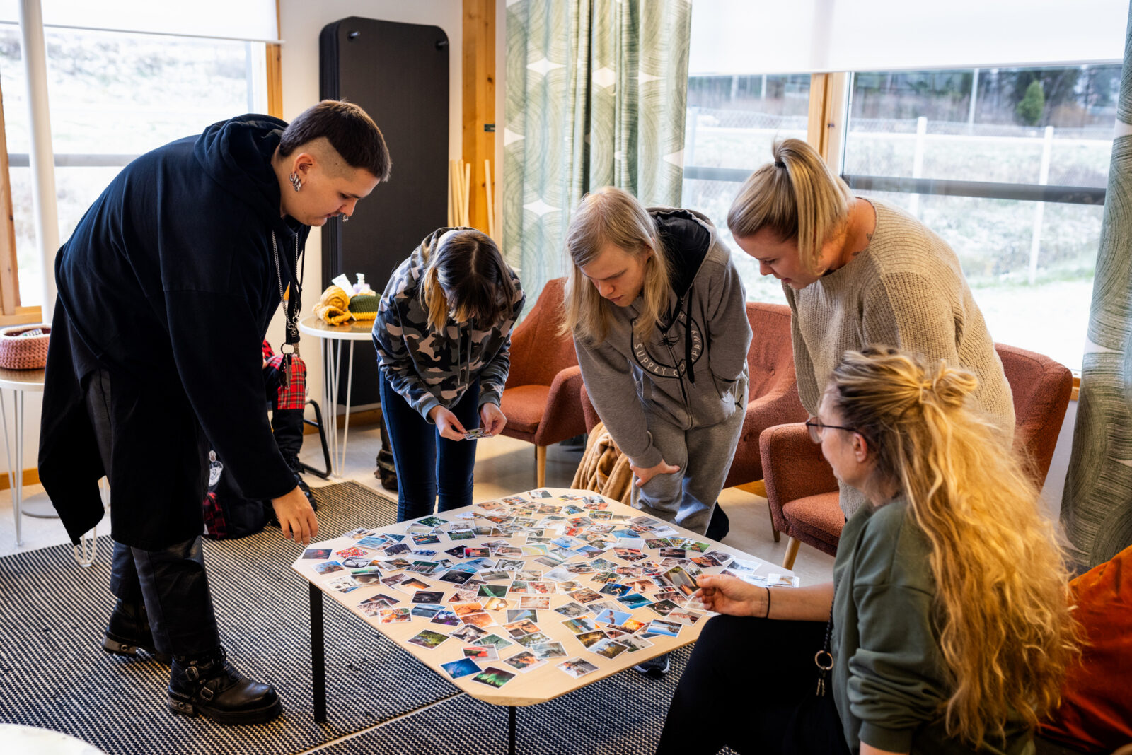 Työ- ja valmennuspalveluiden nuoria ohjaajansa kanssa pöydän ympärillä.