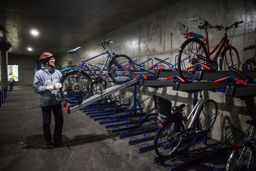 Mies nostaa polkypyörää telineeseen Lahden matkakeskuksen tunnelissa.